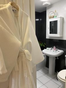 baño con cortina de ducha blanca y lavamanos en Molesworth Arms Pyworthy en Holsworthy