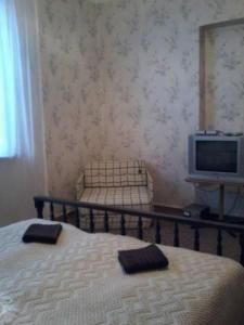 a bedroom with a bed and a tv on a table at Toma's vila in Borjomi