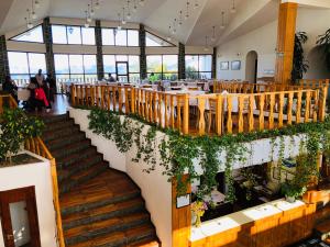 un restaurante con escaleras, mesas y plantas en Hotel Ushuaia en Ushuaia