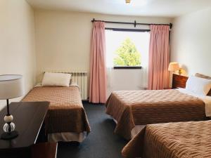 Hotel Ushuaia في أوشوايا: غرفة فندقية بسريرين ونافذة