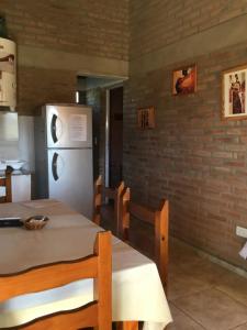 eine Küche mit Tisch und Kühlschrank in der Unterkunft La Soleada casas de campo in Nono