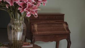 昆明的住宿－昆明若安·對月樓酒店，一张桌子旁的花瓶,上面有粉红色的花朵