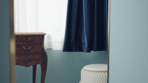 a blue room with a dresser and a blue curtain at Moon and Chalice Boutique Hotel in Kunming