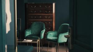 two green chairs in a room with a mirror at Moon and Chalice Boutique Hotel in Kunming