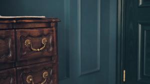 a wooden dresser in a room with a blue wall at Moon and Chalice Boutique Hotel in Kunming