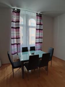 een eetkamer met een glazen tafel en stoelen en een raam bij BonBon Apartment in Wenen