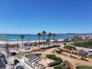 uma vista para um parque com bancos e a praia em Apartamentos Villa Nadine em Playa de Palma