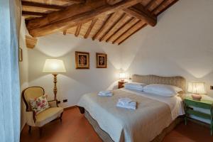 a bedroom with a large bed and a chair at Casa Irene in San Gimignano