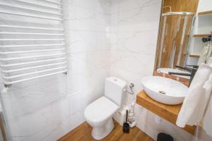 biała łazienka z toaletą i umywalką w obiekcie Black & White Vision Apartment - Centrum w mieście Opole