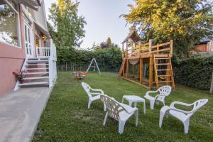 a yard with white chairs and a playground at Apart Altos Del Nahuel in San Carlos de Bariloche