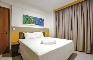 a bedroom with a large white bed and a window at Apartamento em Resort de Olímpia - Direto com Dono Apto 1201 in Olímpia