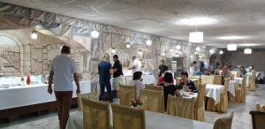 a restaurant with people sitting at tables in a stone wall at Ideal Hotel in Samarkand