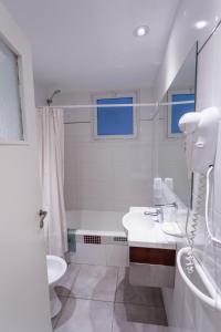 a white bathroom with a sink and a toilet at Estocolmo Hotel by bund in Mar del Plata