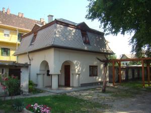una casa blanca con techo de gambrel en Wash House Apartman, en Győr