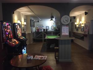 una sala con due giochi arcade e un tavolo da biliardo di The Victoria Hotel a Burnham on Sea