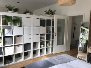 a room with a white bookcase with plants on it at Ferienwohnung City-Apartment Swifts Krefeld in Krefeld