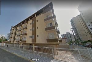 a tall building with a fence in front of it at Apto Aconchegante Praia Grande in Praia Grande