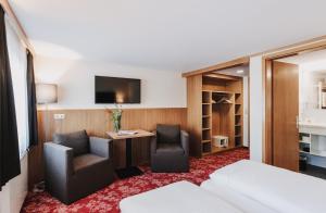 Habitación de hotel con cama, escritorio y silla en Hotel Adler, en Warth am Arlberg