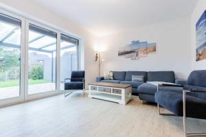 a living room with a blue couch and chairs at Alte Waescherei _9462_ in List