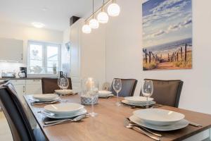 a dining room with a table and chairs and a kitchen at Alte Waescherei _9462_ in List +46 photos