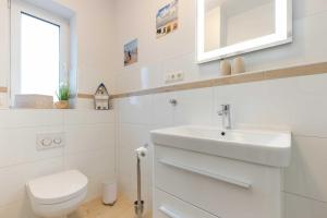 a white bathroom with a toilet and a sink at Alte Waescherei _9461_ in List +36 photos