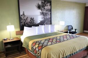 a large bed in a hotel room with two lamps at Super 8 by Wyndham Wells in Wells
