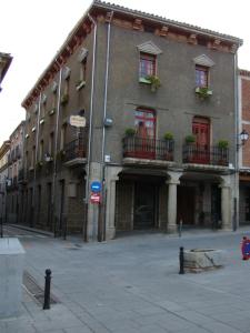 a large brick building with windows and balconies on a street at CASA RURAL PIEDRAHÍTA ( ART DÉCO ) in Piedrahita