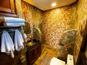 a bathroom with a sink and a stone wall at Riad Chay & Boutique in Ouarzazate