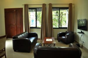 a living room with two leather chairs and a table at Résidence Danna_ALPHA in Douala