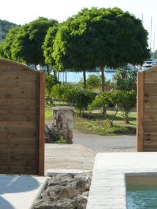ein offenes Tor zu einem Hof mit Bäumen im Hintergrund in der Unterkunft Villa Santa Eufemia in Sutomišćica