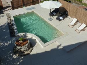 widok na basen z parasolem w obiekcie Vacation home Villa Santa Eufemia w mieście Sutomišćica