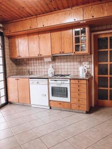 una cocina con electrodomésticos blancos y armarios de madera en Agridia View House, en Limassol