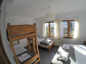 a bedroom with a bunk bed and two beds at Hostería Bärenhaus in San Martín de los Andes