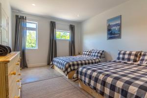 a bedroom with two beds and two windows at Hôtel Val-David - Appartements de la Gare in Val-David