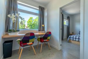 two chairs and a desk in a room with a window at Hôtel Val-David - Appartements de la Gare in Val-David +51 photos