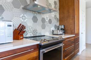 a kitchen with a stove top oven next to a microwave at Hôtel Val-David - Appartements de la Gare in Val-David