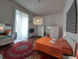 a bedroom with an orange bed and a large window at Casa Cenzina in Cosenza