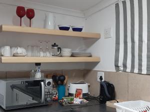 a kitchen with a counter top with a microwave at The Cottage in Grahamstown