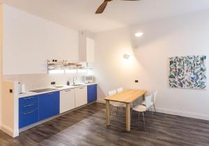 een keuken met blauwe kasten en een houten tafel bij Casa Piazza Erbe 70 mq in Riva del Garda