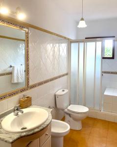 a bathroom with a sink and a toilet and a mirror at Casas Balcón del Mar in El Paso