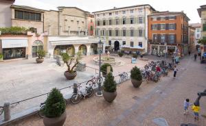 een straat met een groep mensen en fietsen bij Casa Piazza Erbe 70 mq in Riva del Garda