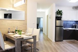 Il comprend une cuisine et une salle à manger avec une table et un réfrigérateur. dans l'établissement LEO Apartment FREE PARKING - Augusta, à Bratislava
