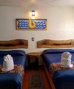 una camera con due letti e un tavolo con asciugamani di Hotel Tlatoani a Chignahuapan