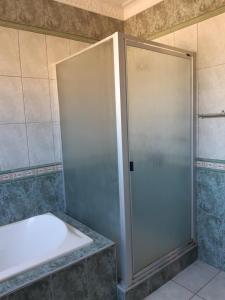 cabina de ducha con puerta en el baño en Angela's Place, en Durban
