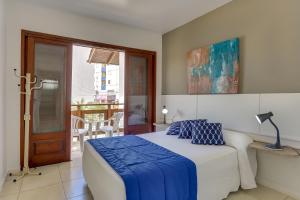 a bedroom with a bed with a blue blanket on it at Pousada Saint Paul in Florianópolis