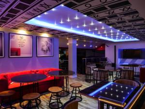 a bar with a red couch and tables and stools at Proof Hotel Lekki in Lagos