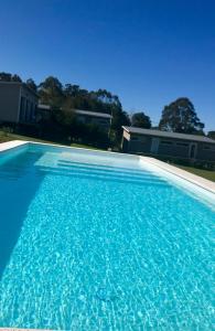 een groot zwembad met blauw water voor een huis bij Hjem Studios in La Pedrera