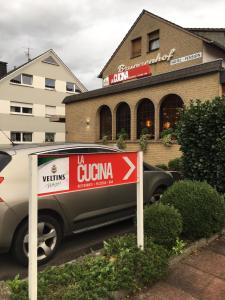 un cartel delante de un coche estacionado en un estacionamiento en Hotel und Pension Brunnenhof en Bad Salzuflen