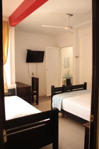 um quarto de hotel com duas camas e uma televisão em Hotel Calle8 em Tuxtla Gutiérrez