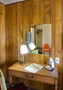 a desk with a lamp and a mirror at Sunset Motel Moriarty in Moriarty